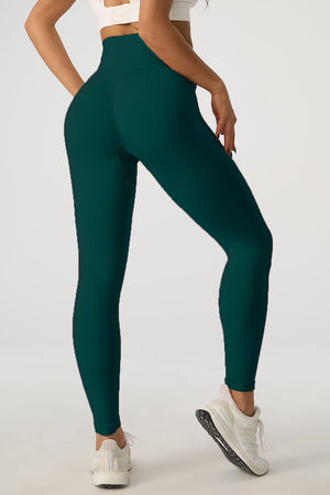 a woman in a white top and green leggings