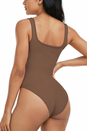 a woman in a brown bodysuit with her back to the camera
