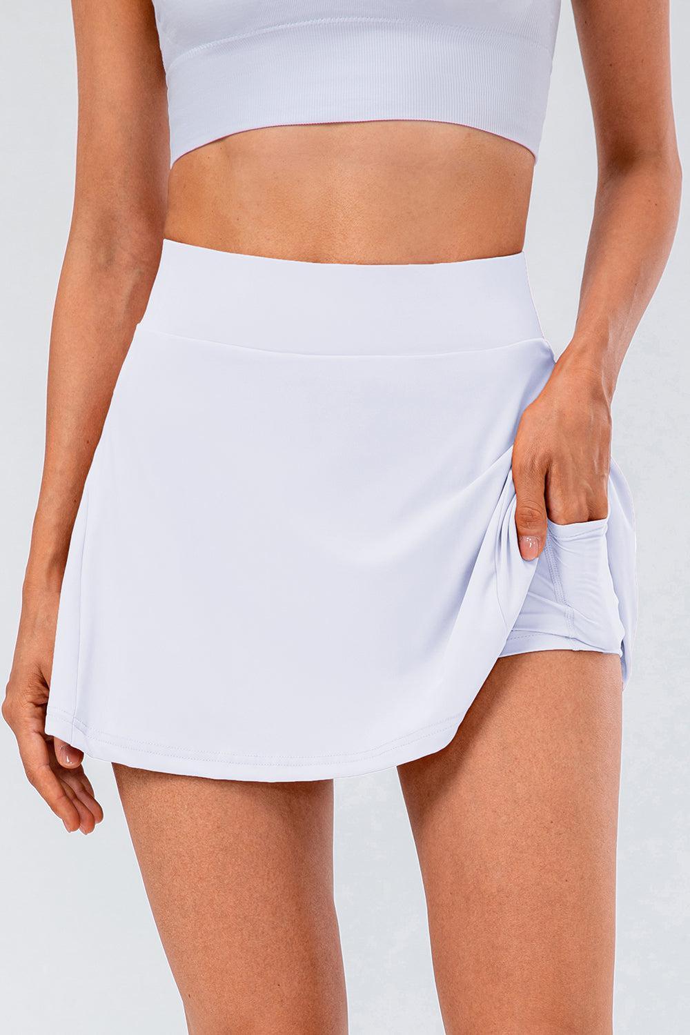 a woman wearing a white tennis skirt