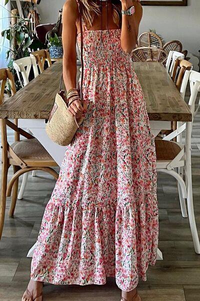 a woman standing in front of a table wearing a dress