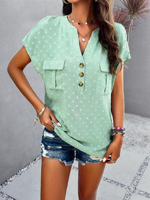 a woman wearing a green shirt and denim shorts