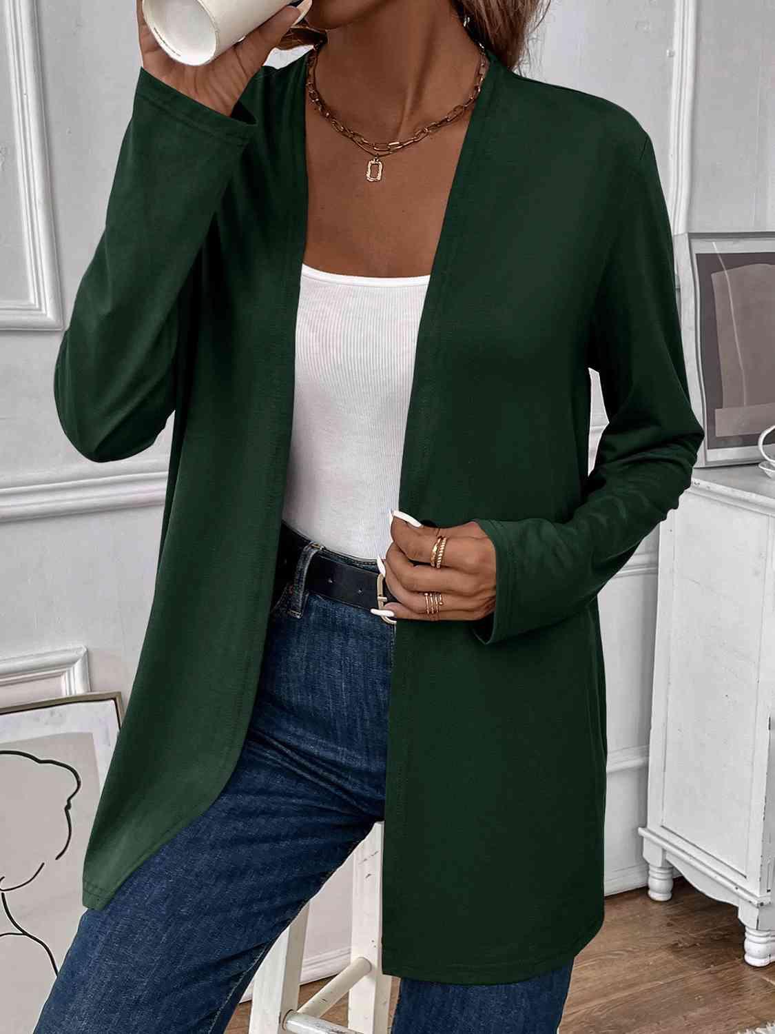 a woman in a green cardigan drinking from a cup