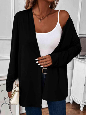 a woman wearing a white tank top and black cardigan