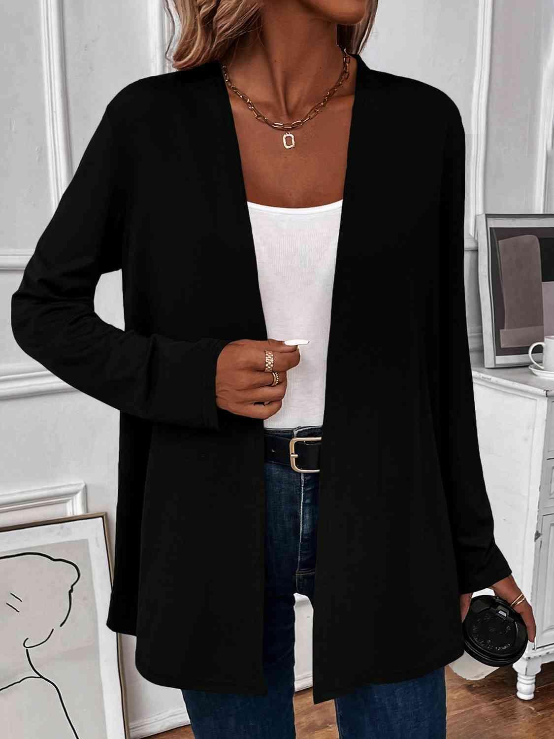 a woman wearing a black cardigan sweater and jeans
