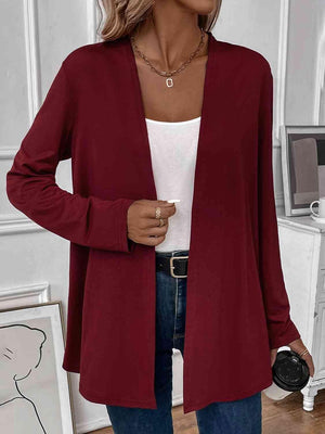 a woman wearing a red cardigan sweater and jeans