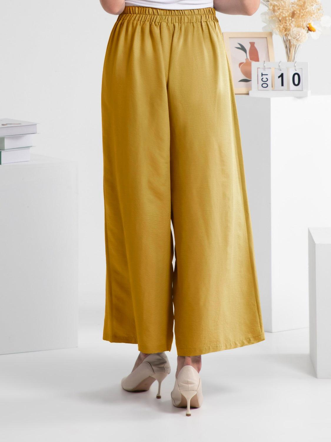 a woman in a white shirt and yellow pants