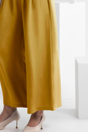 a woman is wearing a pair of yellow pants