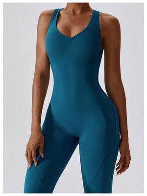 a woman in a blue bodysuit with her hands on her hips