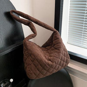 a brown purse sitting on top of a black chair