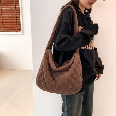 a woman standing next to a wall holding a brown purse