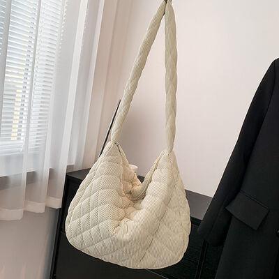 a white purse hanging from a coat rack