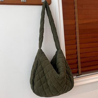 a green purse hanging on a white wall