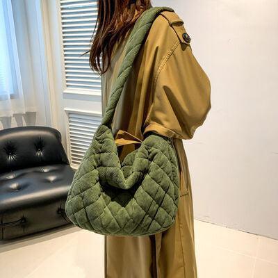 a woman carrying a green quilted purse