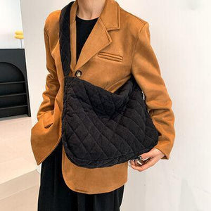 a woman in a brown jacket holding a black purse