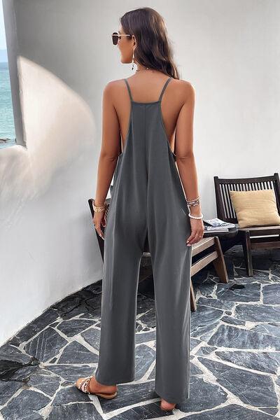 a woman in a gray jumpsuit looking at the ocean