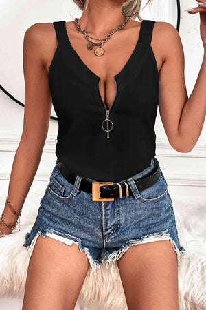 a woman wearing a black top and denim shorts