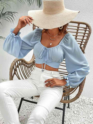 a woman sitting in a chair wearing a straw hat