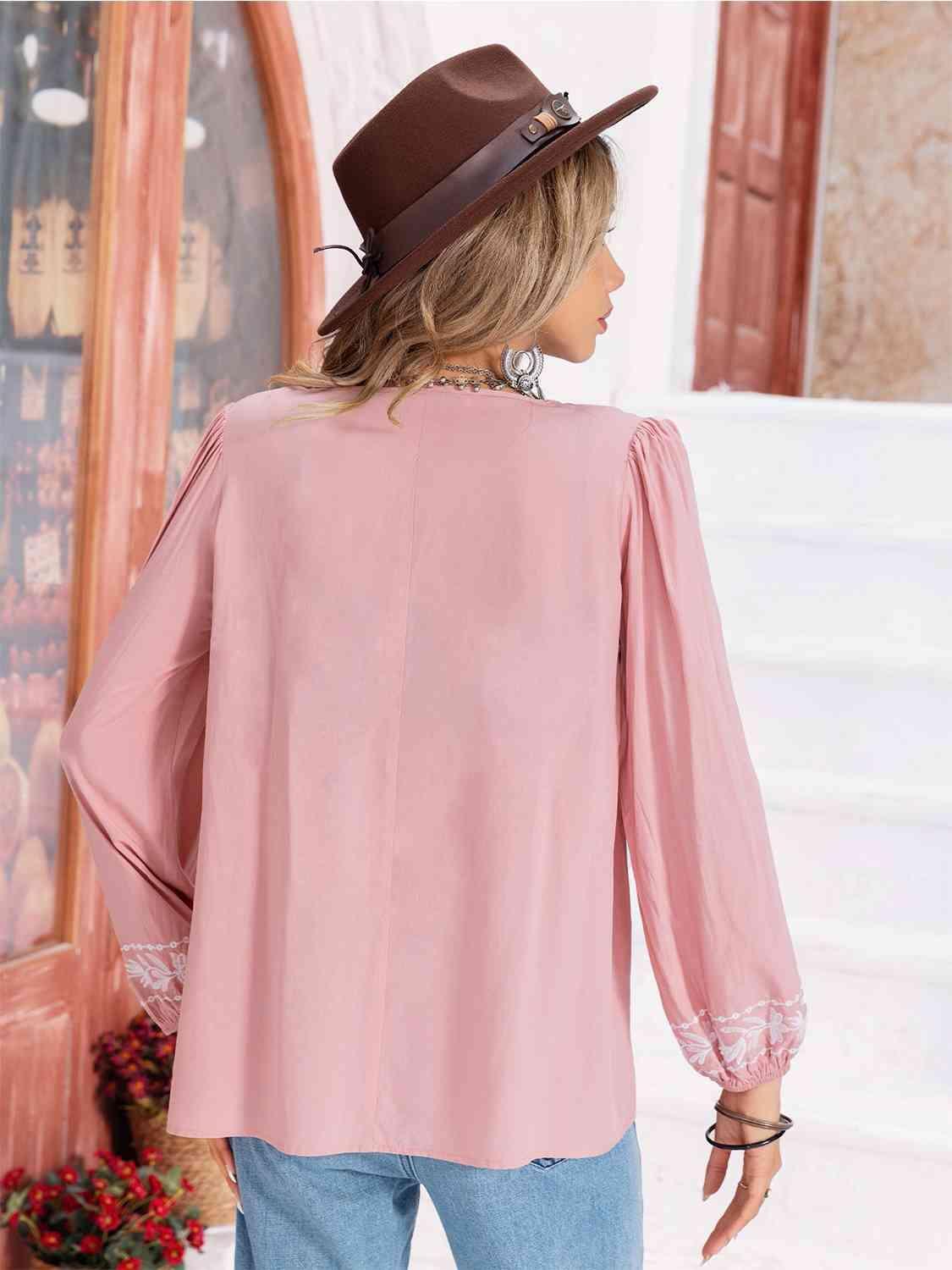 a woman wearing a hat and a pink blouse