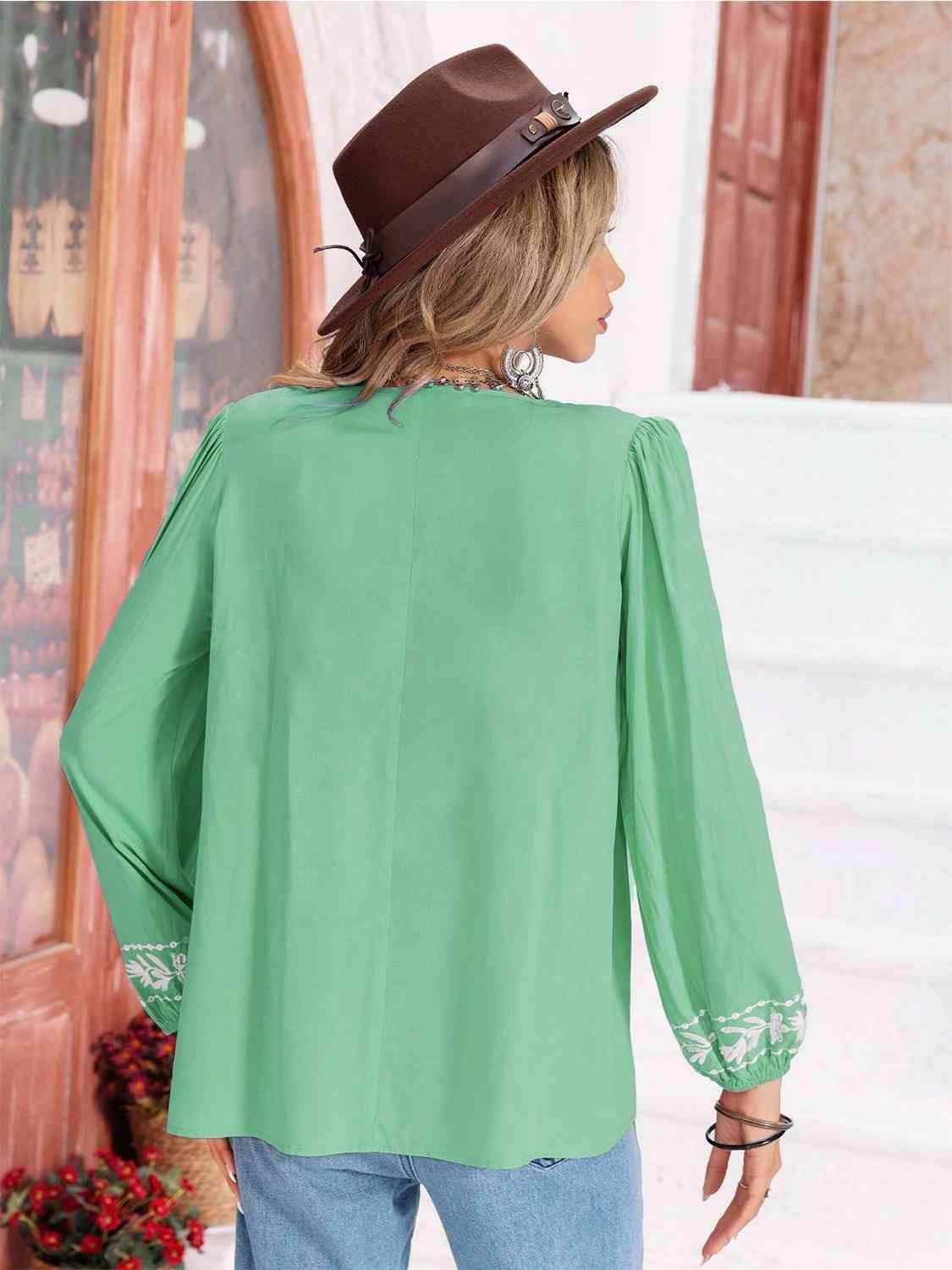 a woman wearing a green blouse and hat