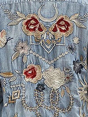a woman wearing a jean jacket with flowers on it