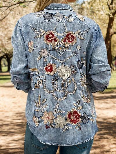 a woman wearing a jean jacket with flowers on it
