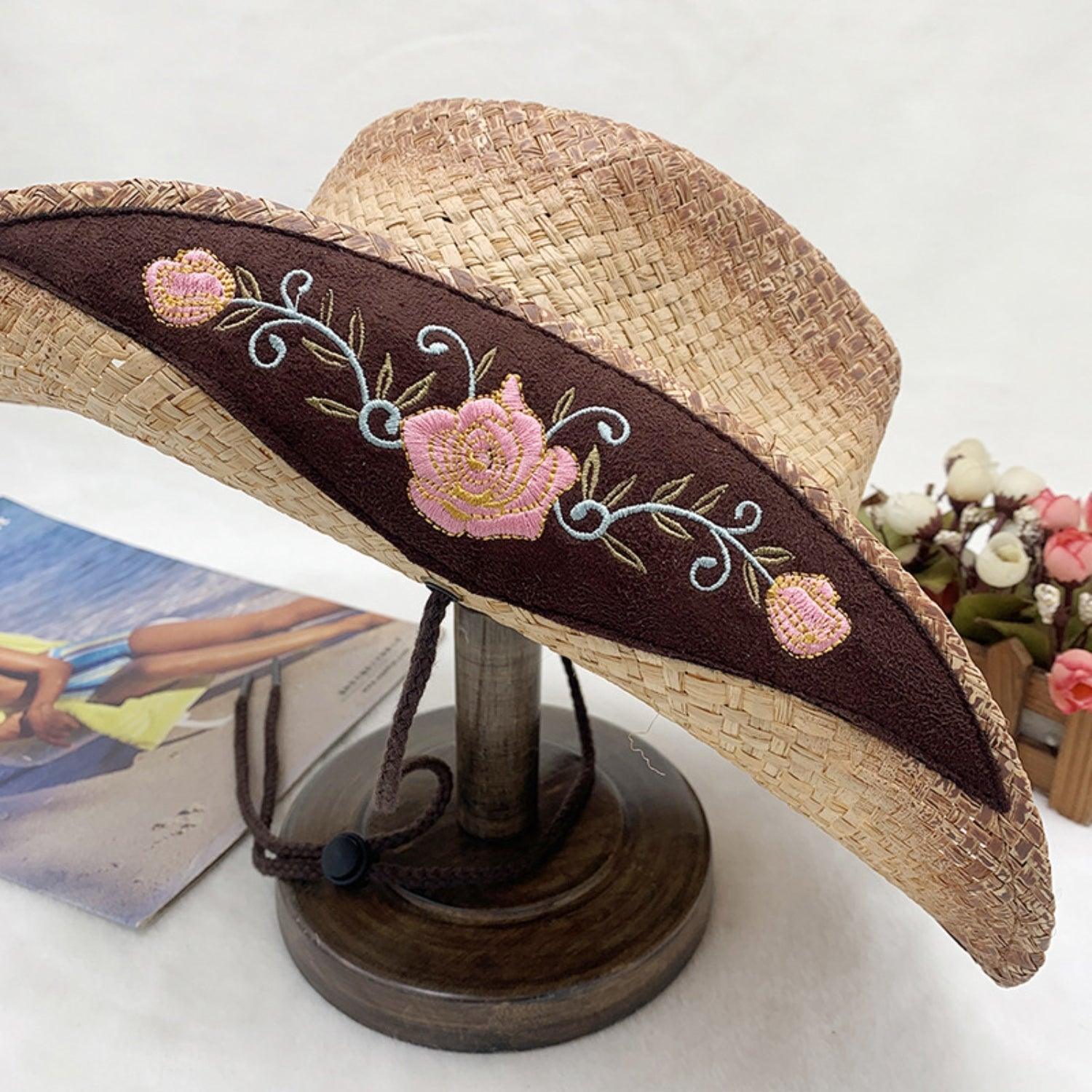 a straw hat with pink flowers on it