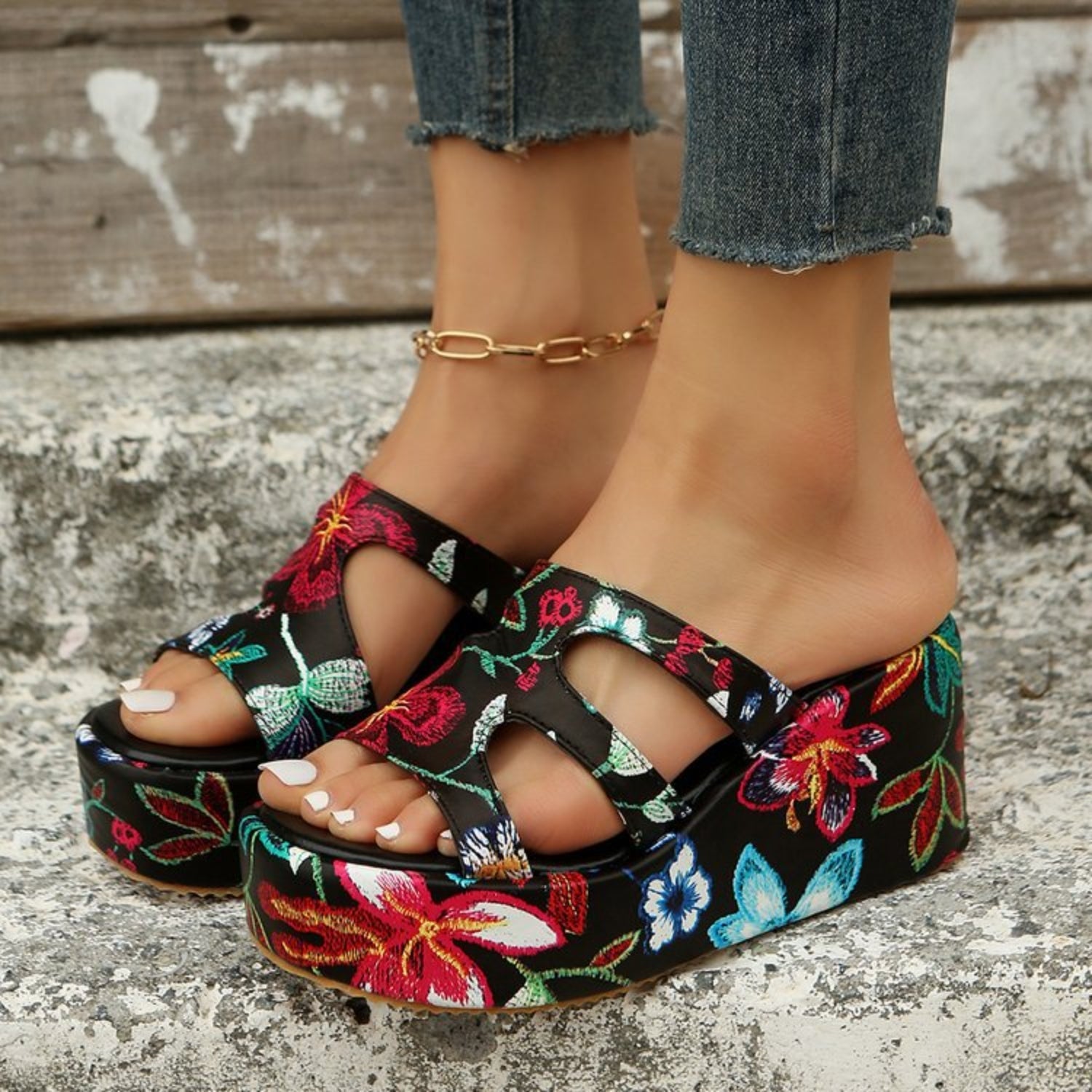 a close up of a person's feet wearing floral sandals