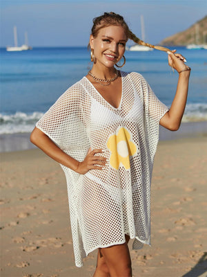 a woman standing on a beach holding a banana