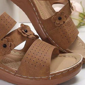 a pair of brown sandals with flowers on them