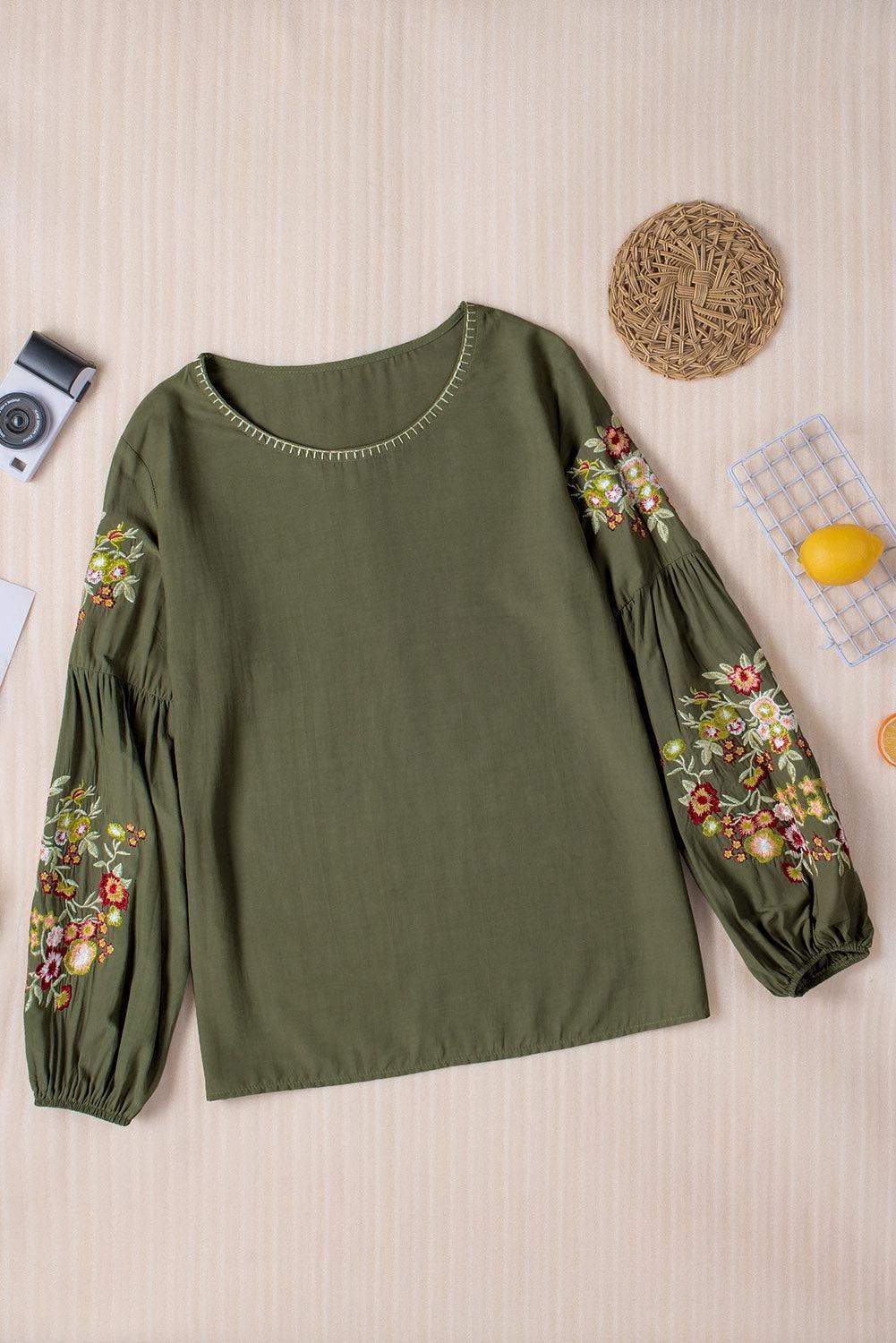 a green top with a floral design on it