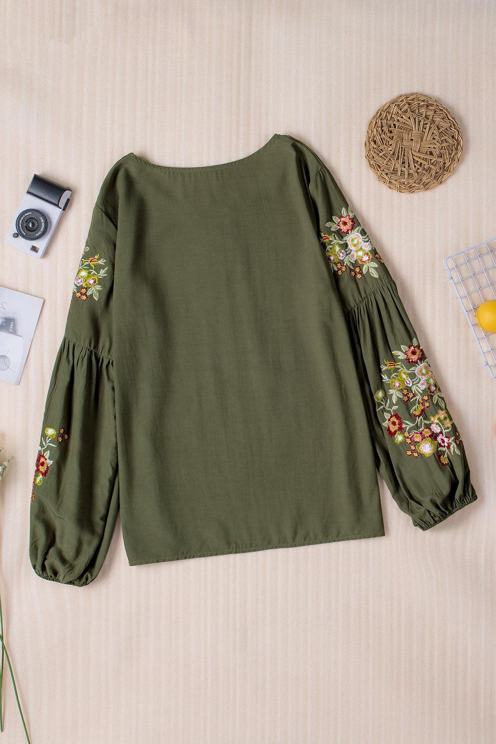 a green blouse with flowers on the sleeves