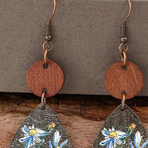 a pair of earrings with flowers painted on them