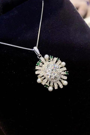 a necklace with pearls and green stones on it