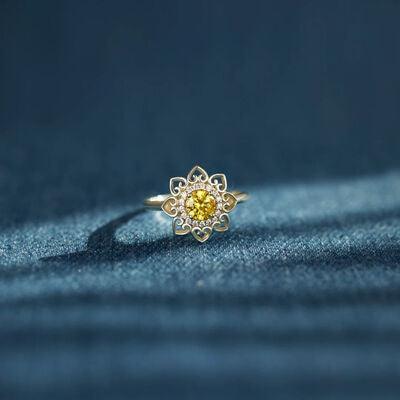 a yellow diamond ring sitting on top of a blue cloth