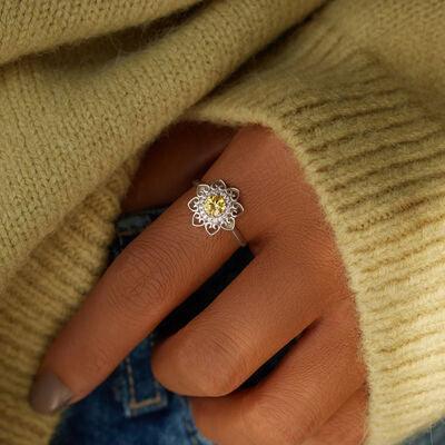 a woman wearing a ring with a flower on it