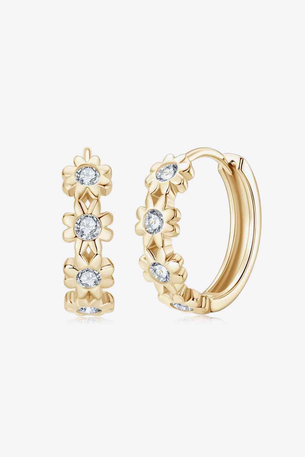 a pair of gold hoop earrings with white stones