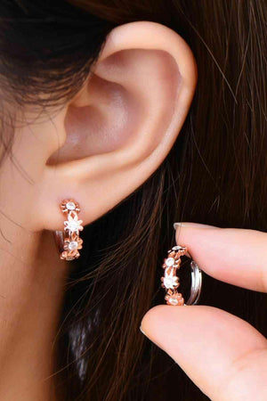 a close up of a person wearing a pair of earrings