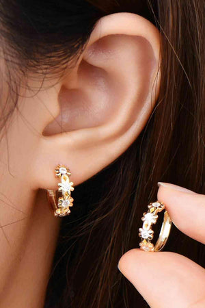 a close up of a person wearing a pair of earrings