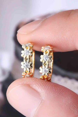 a person is holding a pair of earrings