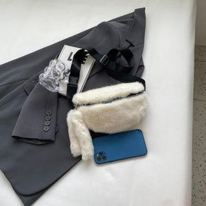 a coat, wallet, and cell phone laying on a bed