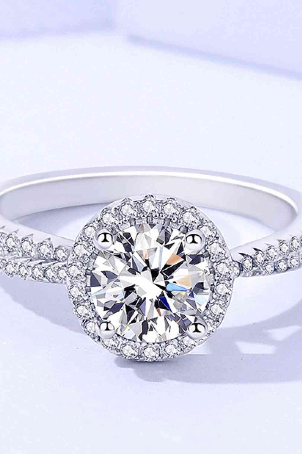 a white gold ring with a diamond center surrounded by diamonds