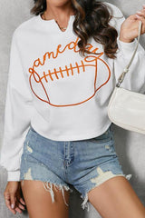 a woman wearing a white sweatshirt with an orange football on it