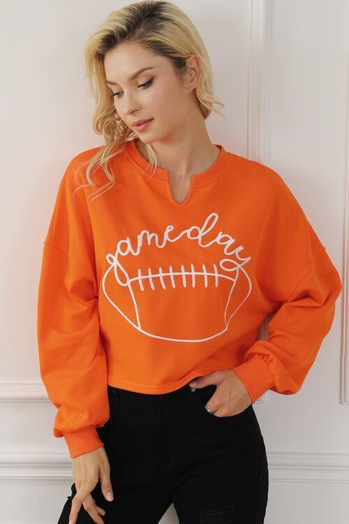 a woman wearing an orange sweatshirt with a football on it