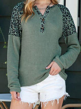 a woman wearing a green sweater and white shorts