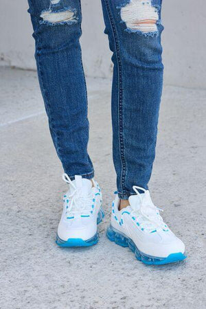 a person wearing ripped jeans and white sneakers