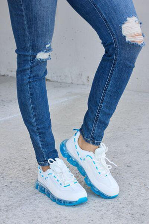 a person wearing ripped jeans and white sneakers