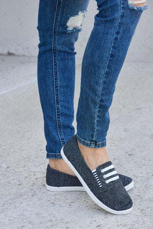 a woman in ripped jeans and black shoes