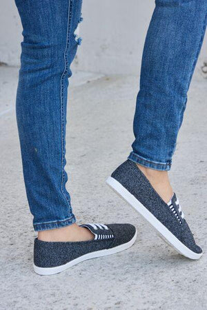 a person wearing blue jeans and black shoes
