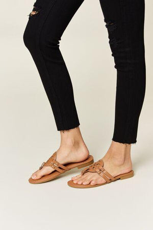 a woman wearing black jeans and a pair of sandals