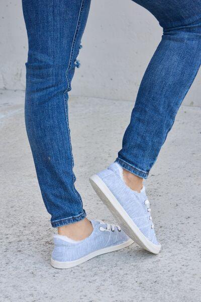 a person wearing blue jeans and white sneakers